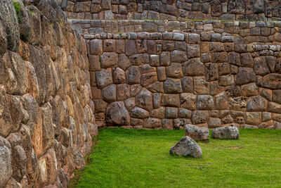 A corner wall with random stones on the ground